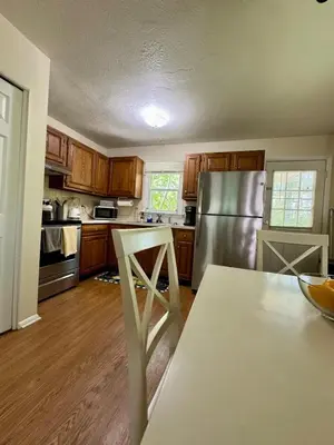 a kitchen with wooden cabinets and a stainless steel refrigerator at The Creekside Oasis Duplex - Central Avon in Avon