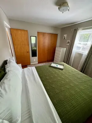 a bedroom with a large bed with a green blanket at The Creekside Oasis Duplex - Central Avon in Avon
