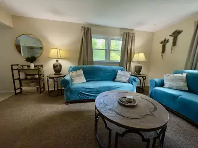 a living room with a blue couch and a table at Avon Nature Retreat by Creek in Avon