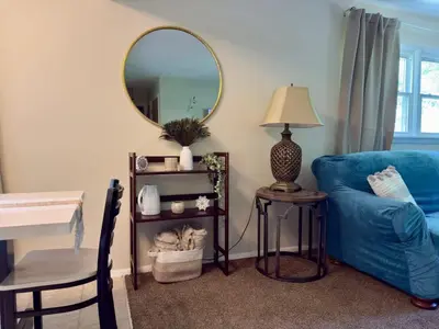 a living room with a blue couch and a mirror at Avon Nature Retreat by Creek in Avon