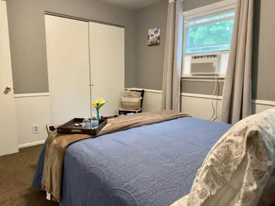 a bedroom with a blue bed and a window at Avon Nature Retreat by Creek in Avon