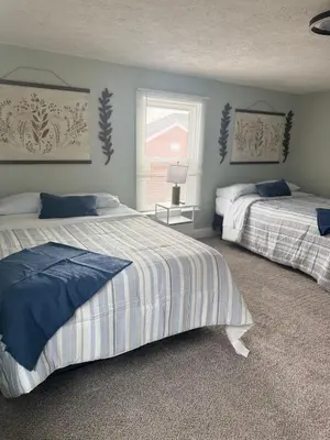 a bedroom with two beds and a window at 3 bed room 5 beds 1 bath sleeps 6 guest in Hamilton