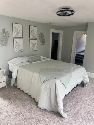 a bedroom with a large bed with white sheets at 3 bed room 5 beds 1 bath sleeps 6 guest in Hamilton