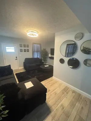a living room with a couch and mirrors on the wall at 3 bed room 5 beds 1 bath sleeps 6 guest in Hamilton