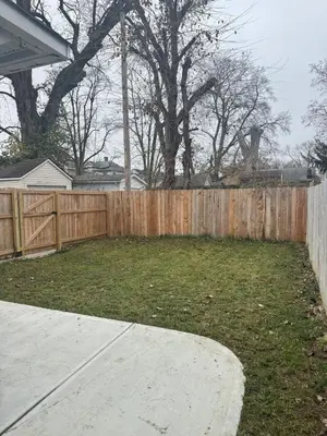 a backyard with a wooden fence and a yard at 3 bed room 5 beds 1 bath sleeps 6 guest in Hamilton
