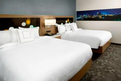 a hotel room with two beds with white sheets at Courtyard by Marriott Akron Downtown in Akron