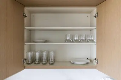 a cupboard with empty glasses and plates and bowls at Luxury Downtown King Bed, Rooftop Pool in Cleveland