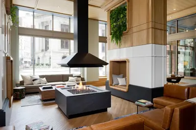 a living room with a fireplace and a couch at Kimpton Schofield Hotel by IHG in Cleveland