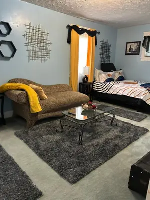 a living room with a couch and a bed at Suite Serenity in Cleveland