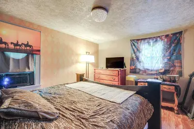 a bedroom with a bed and a dresser and a tv at 7 Mi to Cuyahoga Valley NP Walkable Apt! in Cuyahoga Falls