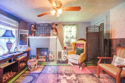a living room with a fireplace and a chair at 7 Mi to Cuyahoga Valley NP Walkable Apt! in Cuyahoga Falls