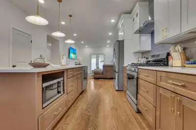 a large kitchen with wooden floors and white cabinets at The Heron House