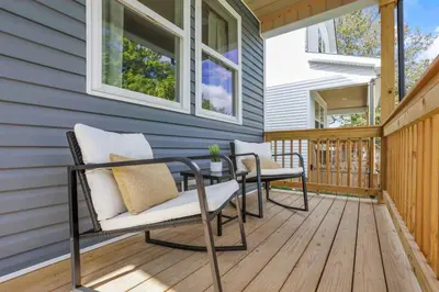 a porch with two chairs and a table on a deck at The Heron House