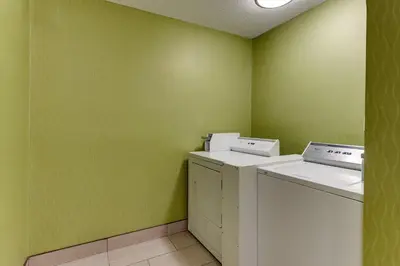 a laundry room with green walls and a washer and dryer at Red Roof Inn Springfield, OH in Springfield