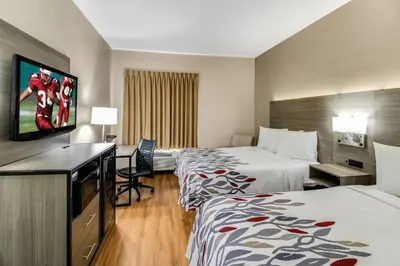 a hotel room with two beds and a flat screen tv at Red Roof Inn Springfield, OH in Springfield