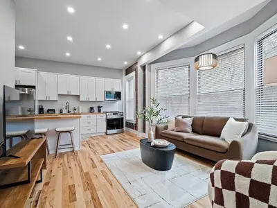 a living room with a couch and a kitchen at The Modern Boho Brick Loft in Cleveland