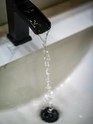 a sink with water coming out of a faucet at The Modern Boho Brick Loft in Cleveland