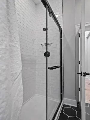 a shower with a glass door in a bathroom at The Modern Boho Brick Loft in Cleveland