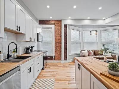 a kitchen with white cabinets and a couch at The Modern Boho Brick Loft in Cleveland