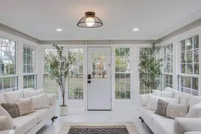 a living room with white furniture and windows at Explore Cleveland Attractions! Family-Focused Home in Shaker Heights