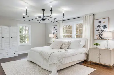 a bedroom with a white bed and a chandelier at Explore Cleveland Attractions! Family-Focused Home in Shaker Heights