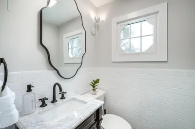 a white bathroom with a sink and a mirror at Explore Cleveland Attractions! Family-Focused Home in Shaker Heights