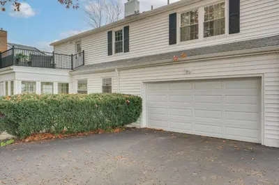 a white house with a garage and a driveway at Explore Cleveland Attractions! Family-Focused Home in Shaker Heights