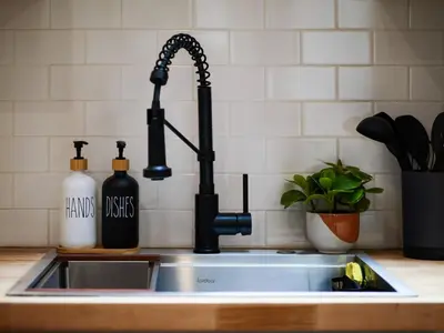 a kitchen sink with a black kitchen faucet at The Brick Treasury Loft in Cleveland