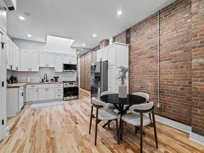 a kitchen with a brick wall and a table and chairs at The Brick Treasury Loft in Cleveland