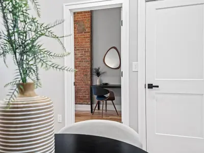 a room with a table and a chair and a mirror at The Brick Treasury Loft in Cleveland