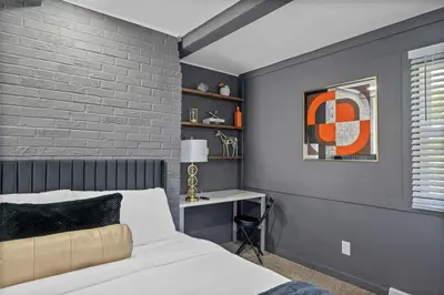 a bedroom with a bed and a brick wall at Luxury 5BR Cincinnati, Sleeps 12, Crib, Home Gym, Fenced Backyard in Cincinnati