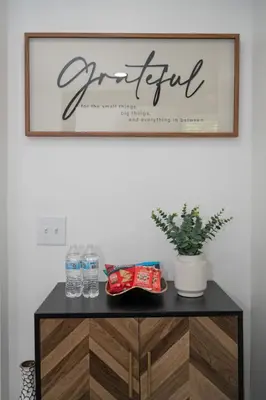 a sign on a wall above a cabinet with water bottles at Luxury 5BR Cincinnati, Sleeps 12, Crib, Home Gym, Fenced Backyard in Cincinnati