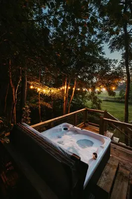 a bath tub sitting on a deck with lights at The Pinnacle in Logan