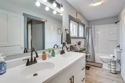 a white bathroom with a sink and a toilet at 5 Mi to The Wilds Spacious Family Hub, Game Room!