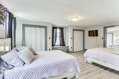 a white bedroom with two beds and a window at 5 Mi to The Wilds Spacious Family Hub, Game Room!