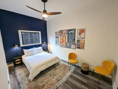 a bedroom with a bed and two chairs at Downtown 3 Bed Loft Apartment in Delaware