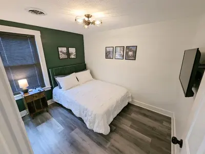 a bedroom with a bed and a green wall at Downtown 3 Bed Loft Apartment in Delaware
