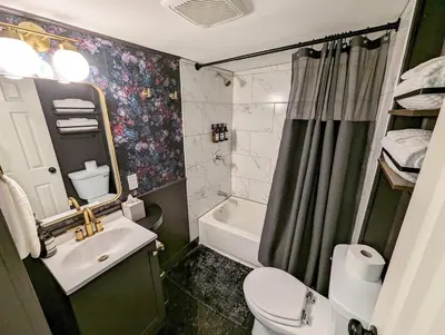 a bathroom with a sink and a toilet and a shower at Downtown 3 Bed Loft Apartment in Delaware