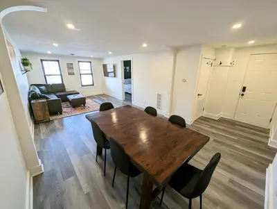 a living room with a wooden table and chairs at Downtown 3 Bed Loft Apartment in Delaware