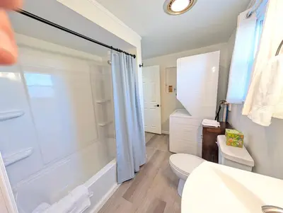 a bathroom with a tub and a toilet and a sink at Modern Norwalk Retreat 2 King Suites Sunroom in Norwalk