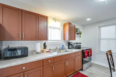 a kitchen with wooden cabinets and a sink and a microwave at Cozy Old Brooklyn Home near Zoo in Cleveland