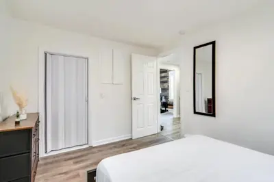 a bedroom with a bed and a desk and a mirror at Cozy Old Brooklyn Home near Zoo in Cleveland