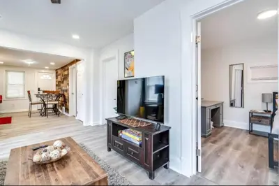 a living room with a television and a table at Cozy Old Brooklyn Home near Zoo in Cleveland