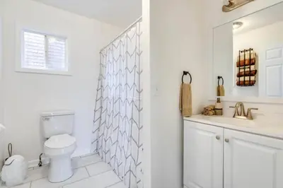 a white bathroom with a toilet and a sink at Cozy Old Brooklyn Home near Zoo in Cleveland