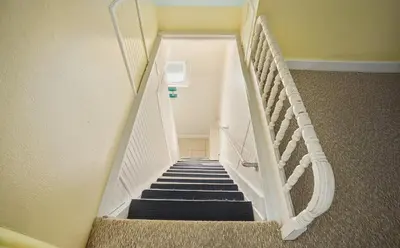 a staircase with black and white stairs in a house at Angler's Cottage with Boat Parking by Lake Erie in Port Clinton