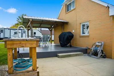 a deck with a tent and chairs on a house at Angler's Cottage with Boat Parking by Lake Erie in Port Clinton