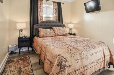 a bedroom with a large bed and a television at Angler's Cottage with Boat Parking by Lake Erie in Port Clinton