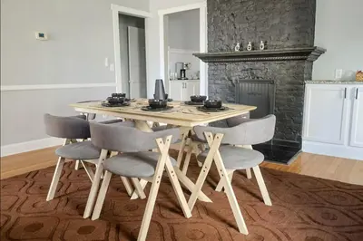 a dining room table with four chairs and a fireplace at Spacious Home Downtown - Children's Hospital, Pets in Columbus