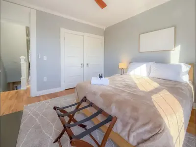 a bedroom with a large bed with a chair at Spacious Home Downtown - Children's Hospital, Pets in Columbus