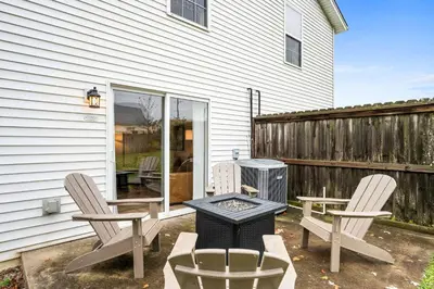 a backyard with a grill and two chairs and a fire pit at Fire Ring Private Parking King Beds - Near Ark in Dry Ridge